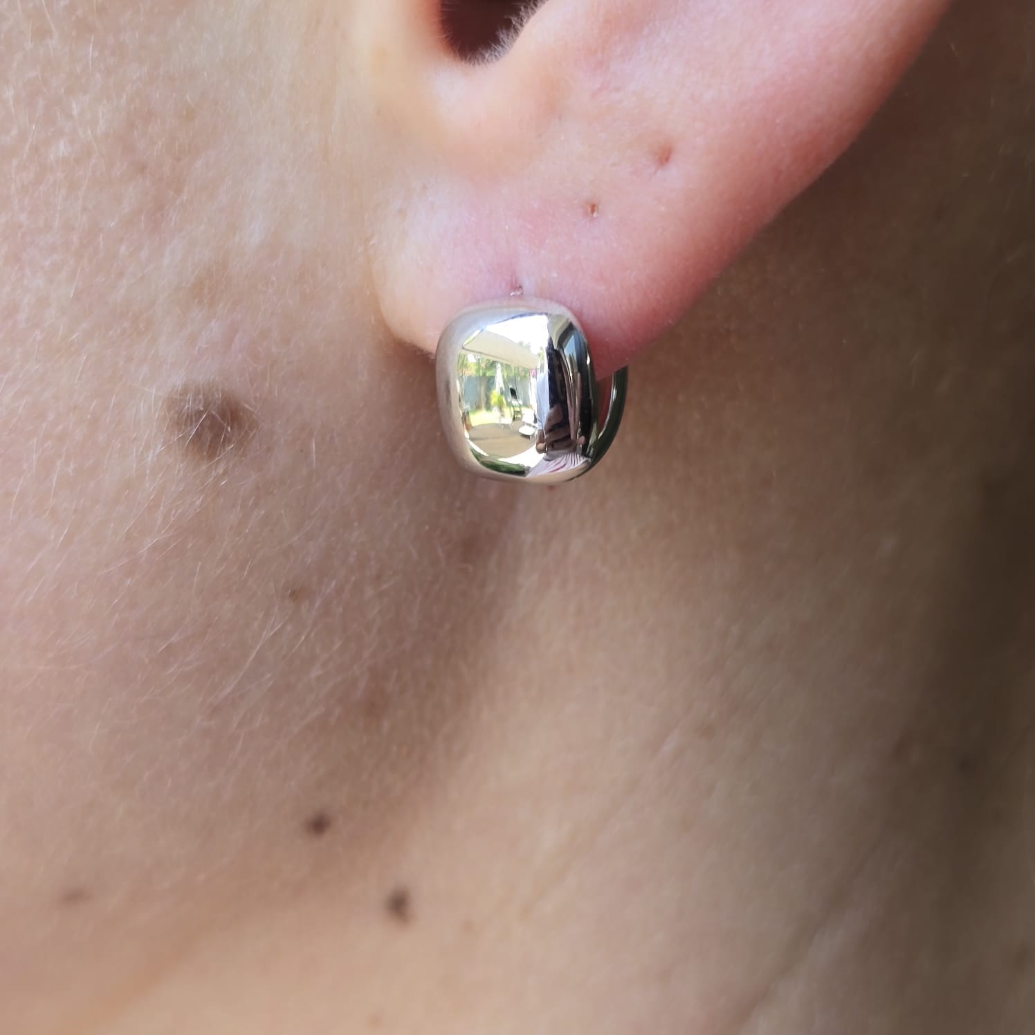 Button Huggie Earrings worn on ear minimal clean design